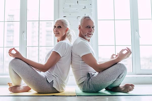 Couple in back to back Yoga poise